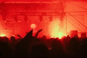 Rock concert crowd with red flares and smoke