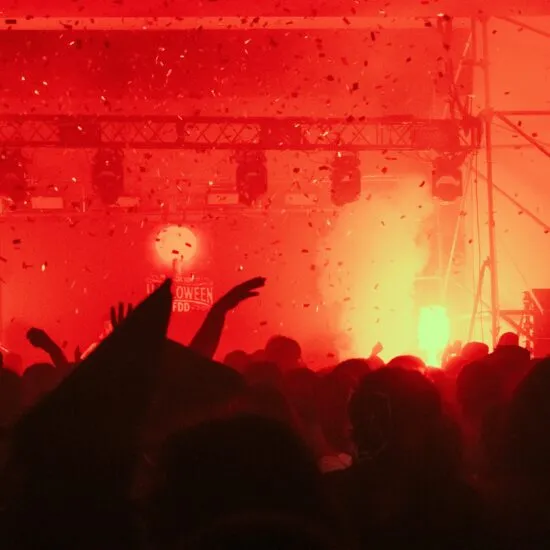 Rock concert crowd with red flares and smoke